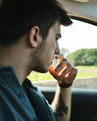 Portrait of young man smoking cigarette in car