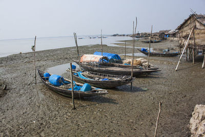 Fishing boats moored on beach against clear sky. sundarban. khulna, bangladesh