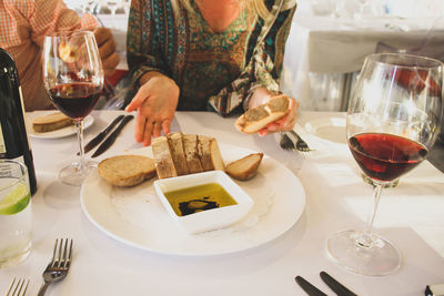 Midsection of woman sitting with meal at restaurant