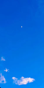 Low angle view of moon in blue sky