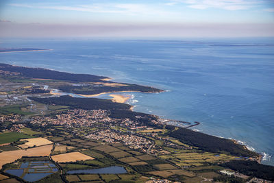 High angle view of townscape by sea against sky