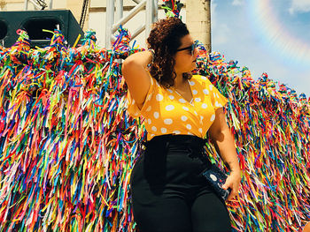 Midsection of woman standing against multi colored wall