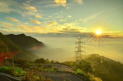 Cars on road against sky during sunset