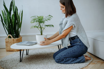 Young woman using mobile phone while sitting at home