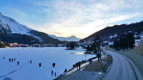 Panoramic view of people on snow covered mountain against sky