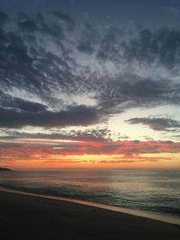 Scenic view of sea against dramatic sky during sunset