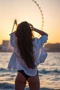 Young woman at the beach at sunset