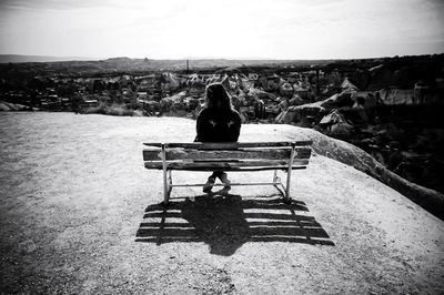 Rear view of woman sitting on bench