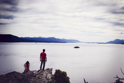 Rear view of woman looking at mountains against sky