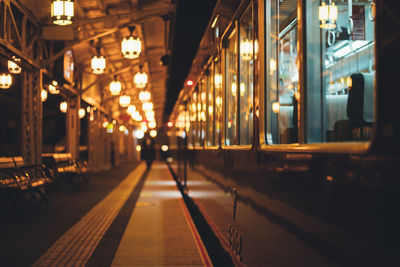 Illuminated railroad tracks in city at night