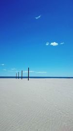 Scenic view of beach against blue sky