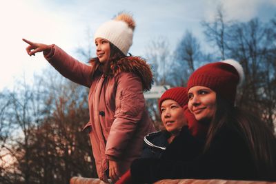 Young woman wearing hat against trees during winter