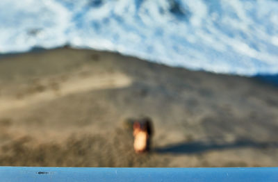 Close-up of blurred motion of sand at beach against sky