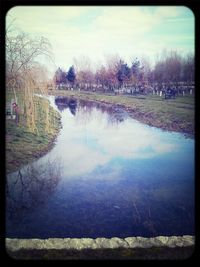 Scenic view of river against cloudy sky