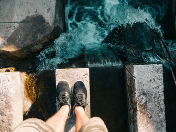 Low section of man standing in water