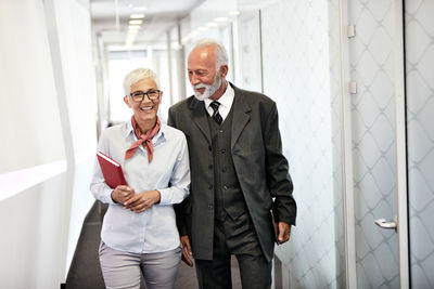 Businesswoman discussing with colleague while walking in office