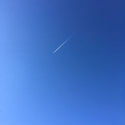 Distant view of vapor trail in blue sky