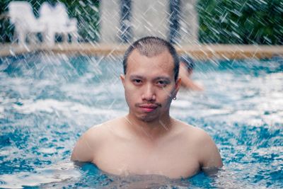 Portrait of shirtless man swimming in pool