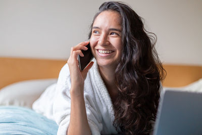 Young woman using mobile phone at home