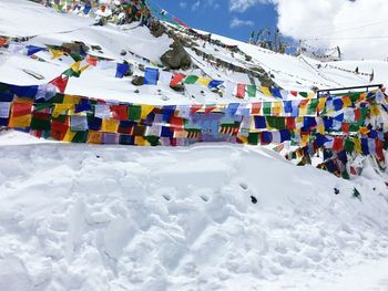 Low angle view of colorful prayer flags on snow covered mountain