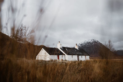 Houses on land against sky during winter