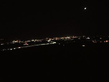 Illuminated city against sky at night