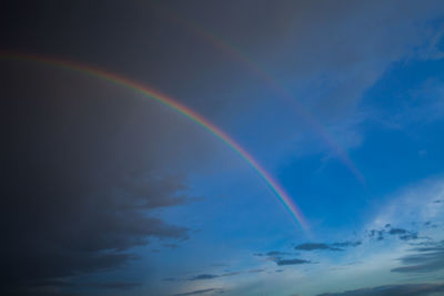 Low angle view of rainbow against blue sky