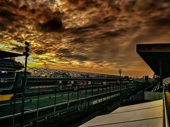 Railroad track against cloudy sky at sunset