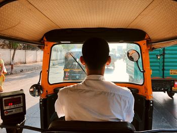 Rear view of man riding auto rickshaw