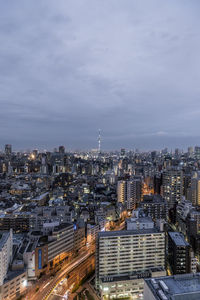 Aerial view of buildings in city against sky