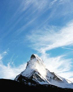 Low angle view of snowcapped mountains against sky