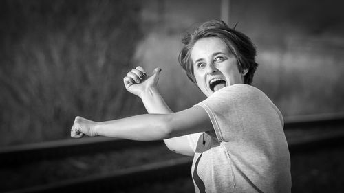 Cheerful woman hitch hiking on street