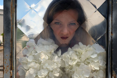 Portrait of young woman holding white flowers