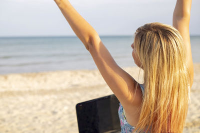 Rear view of woman standing at beach