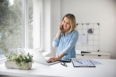 Smiling businesswoman working at office