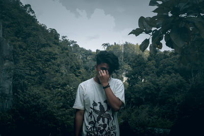 Portrait of young man looking at trees