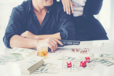 Portrait of businesswoman gambling while sitting on table at office