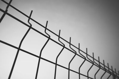 Low angle view of fence against clear sky