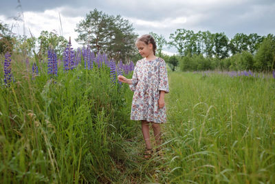 Rear view of girl standing amidst plants