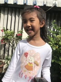 Portrait of cute girl standing against plants