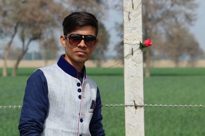 Portrait of young man wearing sunglasses standing outdoors