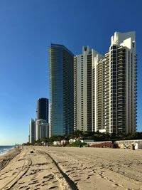 Modern buildings in city against clear blue sky