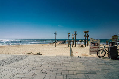 Scenic view of beach against clear blue sky