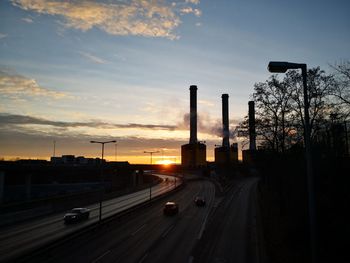 Cars on road against sky during sunset