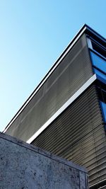 Low angle view of modern building against blue sky