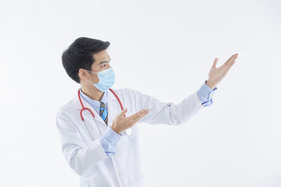 Young man looking away against white background