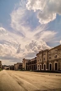 Buildings in city against cloudy sky