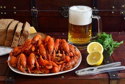 Close-up of lobsters with bread and drink on table