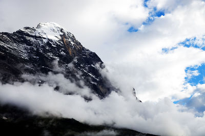 Scenic view of snowcapped eiger against cloudy sky during foggy weather at grindelwald