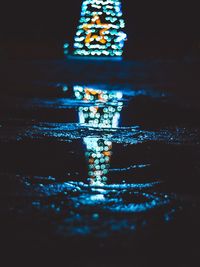 Close-up of illuminated lighting equipment in water at night